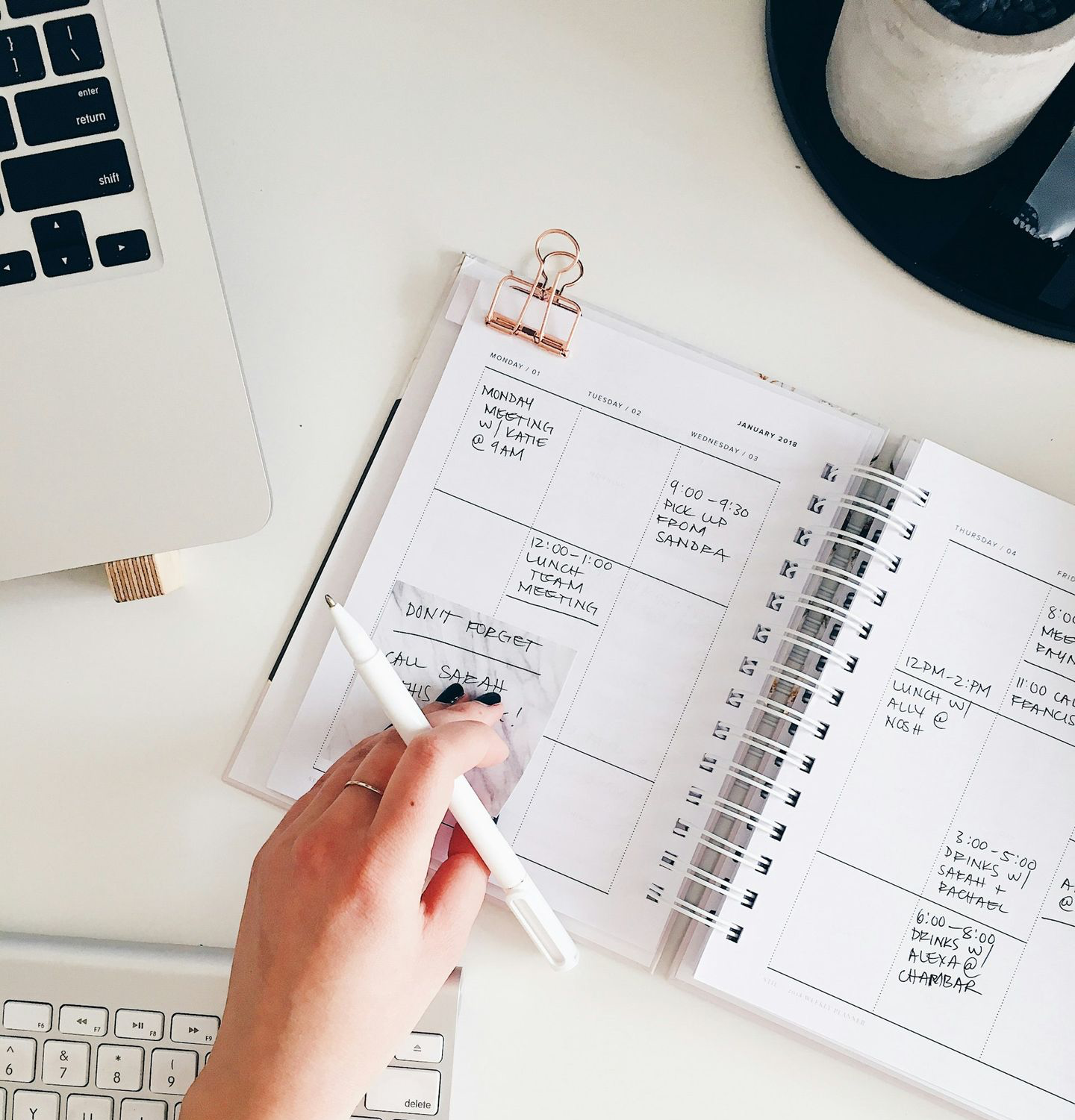 person holding notepad and pen flat lay photography